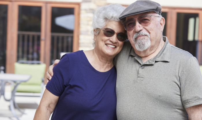 An elderly couple embrace