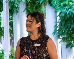 A young woman smiles as she accepts an award.